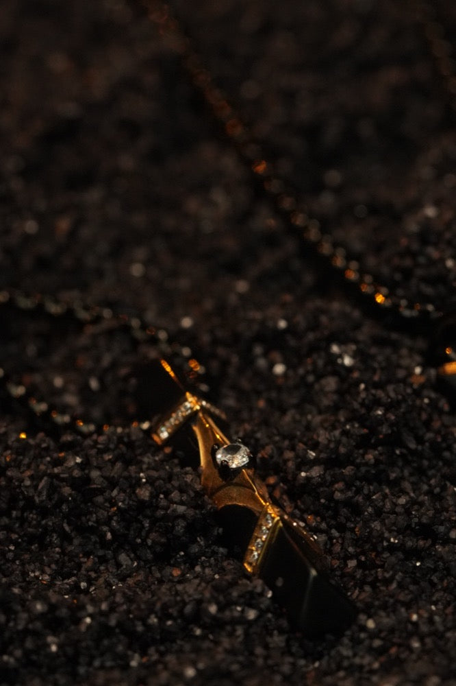 A single point of gold light in near-total darkness — the collection, still withheld